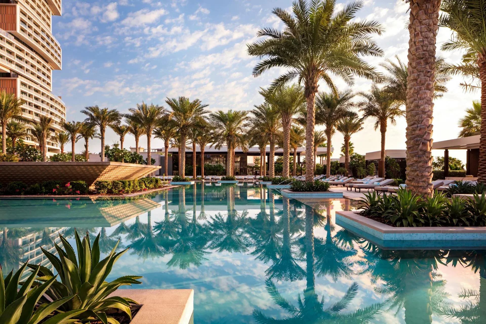 Palm-lined pool and sun loungers at Nobu by the Beach in Dubai